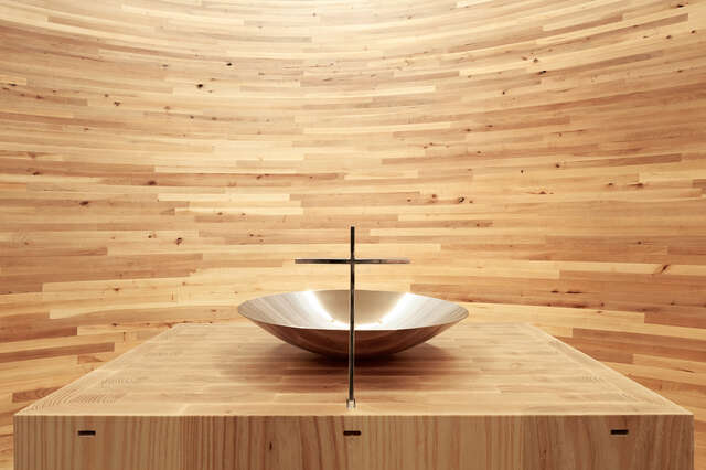 Wooden altar with a minimalistic cross and baptismal font