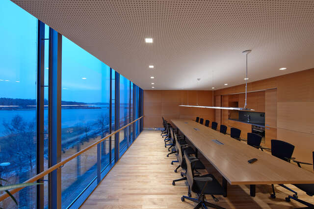 Meeting room with wooden elements and view to a sea from left wall window