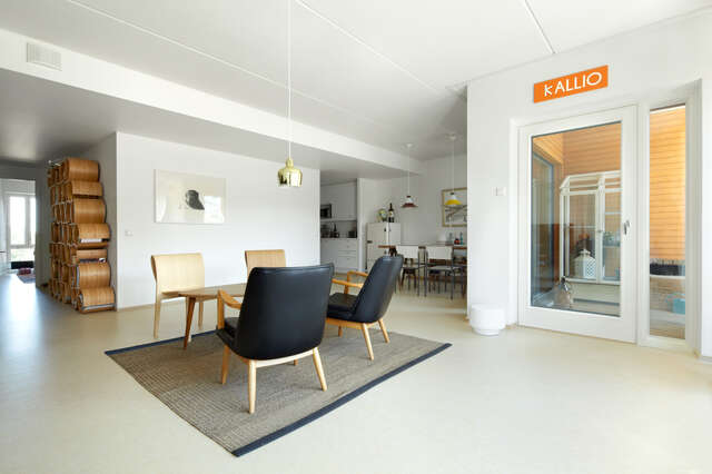 White-walled view from a sitting area to a terrace, kitchen and a corridor
