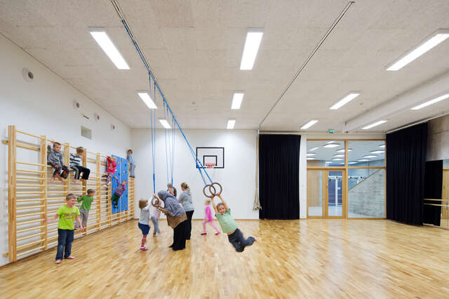 White and light gym room with children and teacher, wooden floor