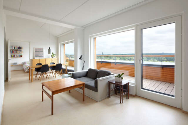 Living and dining room with a view to a bedroom and a long terrace