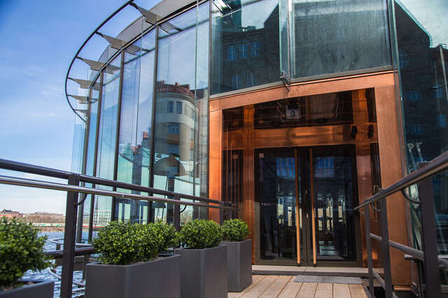 The copper entrance to the restaurant contrasts with the otherwise glass facade.