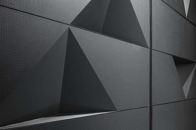 Black wall with triangle indents and small dotted texture.