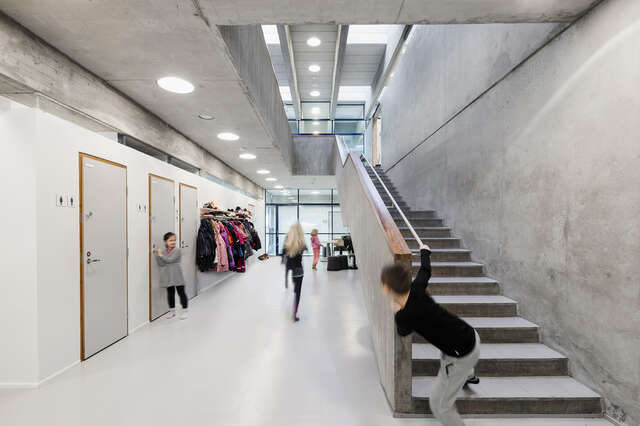 Hallway with stairs leading to the first floor, children walk in the hallway.
