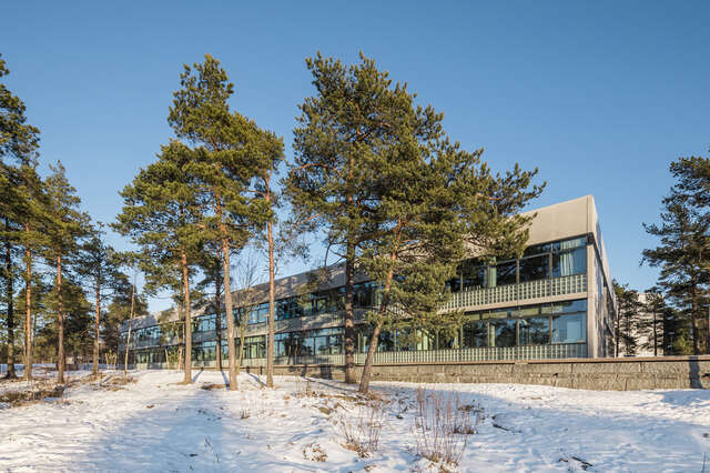 Back facade of eh building with trees in front of it.