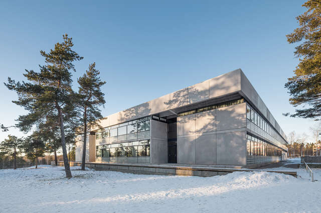 Side of the school building with concrete and glass elements on a snowy day.