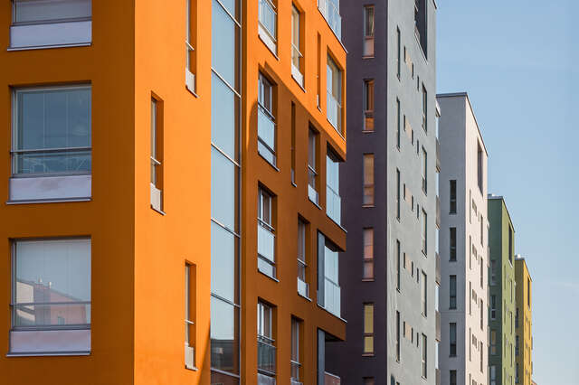 Close up shot of different colored apartment buildings in a row.