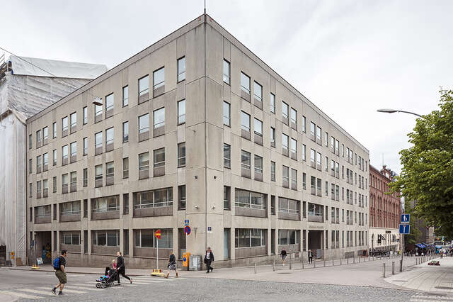Grey plastered building with a dirty facade.