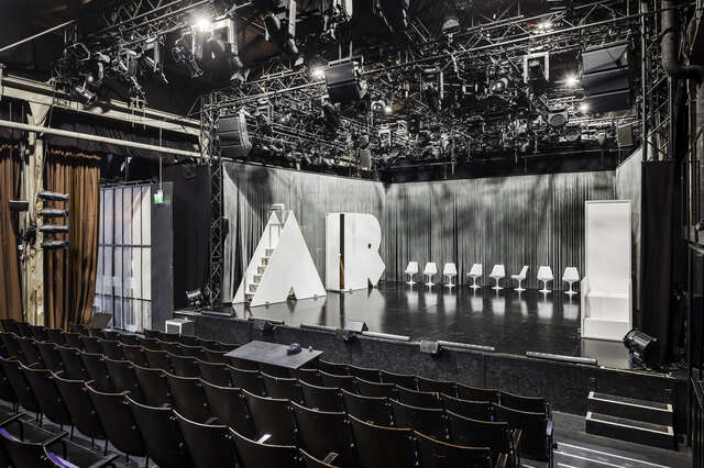 A black and white photo of a theatre stage and stands.