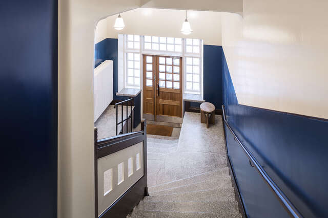 The lobby and stairwell of an old stone building.