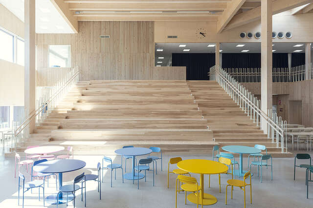 A lobby with a large wooden staircase and a colourful seating area