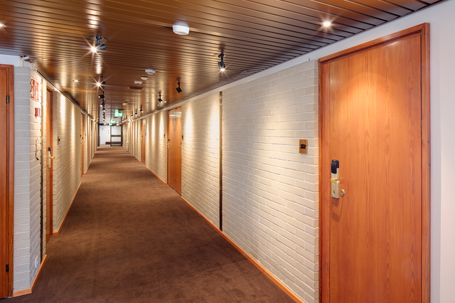Hallway with white walls and wooden doors
