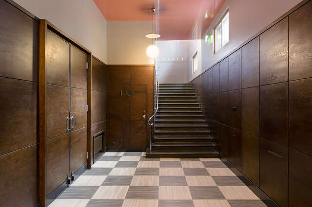 Wardrobe room with dark wooden panels and stairs.