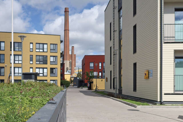 Yellow, red and white blocks of flats, factory chimneys in the distance
