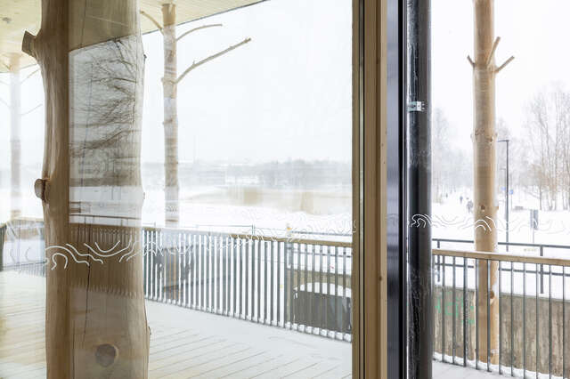 View of Töölönlahti bay from inside the building through a glass window with some reflections on it.