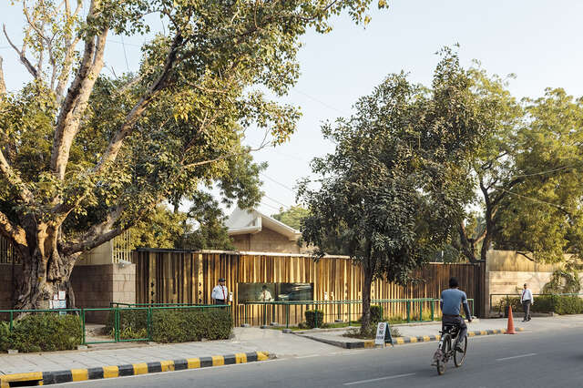 Street view of the building and the gold colored fence front of it.