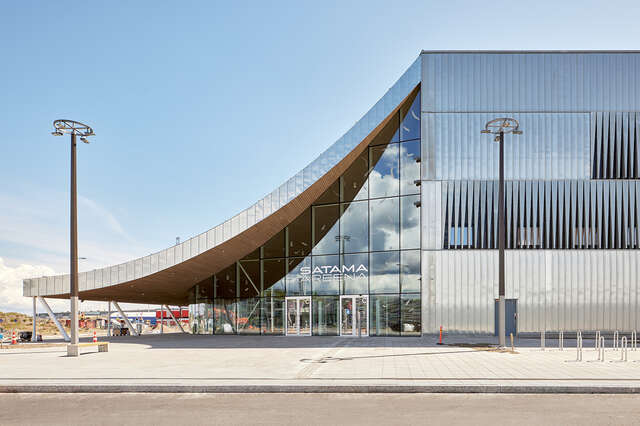 Side view of entrance side to a zinc-covered building with a hanging canopy-like structure