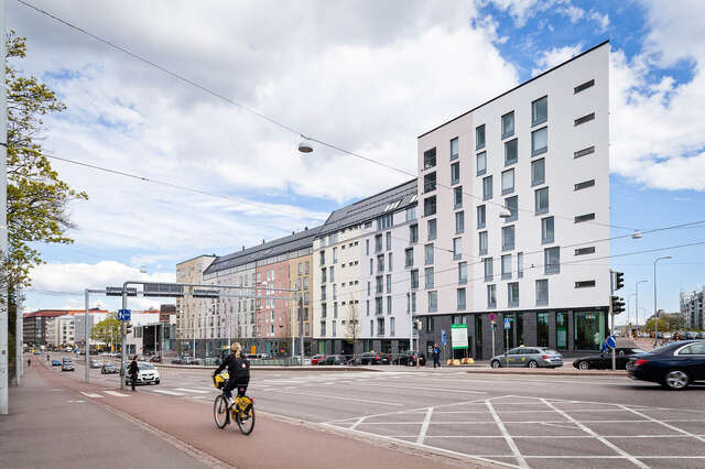 Pastel colored apartment building facade viewed from the other side of the street.
