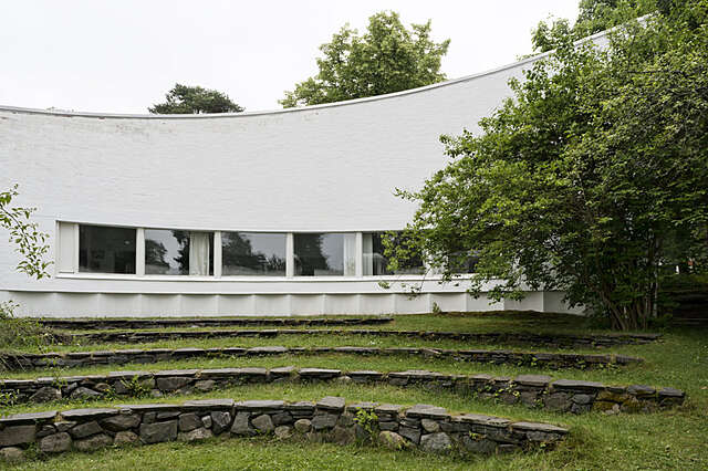 Curved white facade with a garden shaped like an amphitheater.