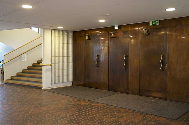 Interior with brown floor tiles, white walls and ceiling and copper walls and the surrounding wall.