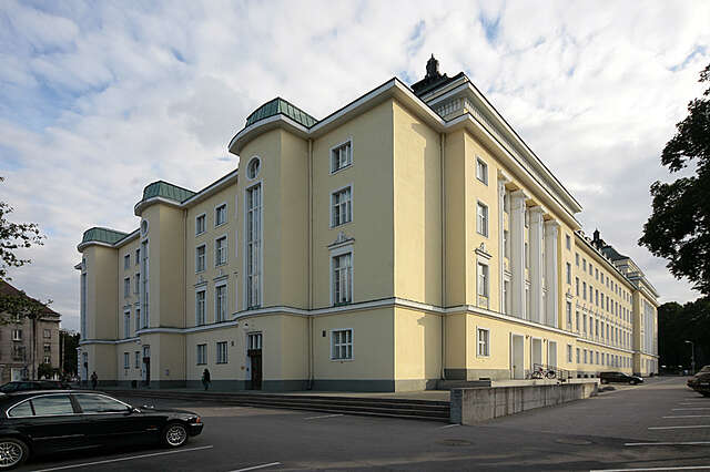 Yellow multiple storey building with white structural elements and decorations.
