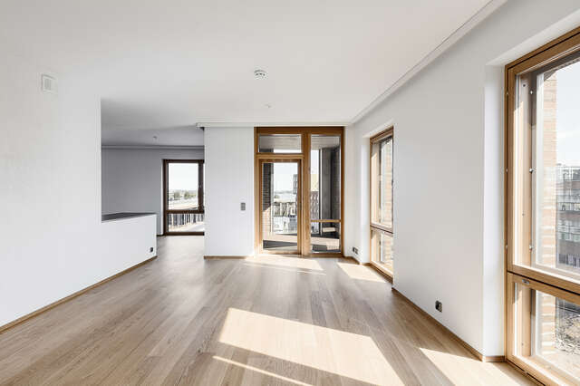Empty room interior with white walls and brown wooden windowframes.