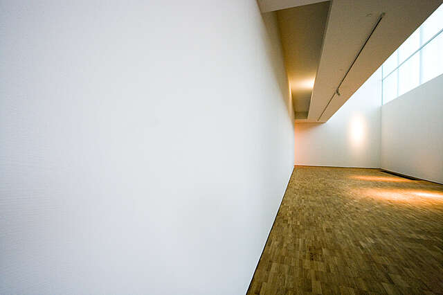 White room with wooden floor.