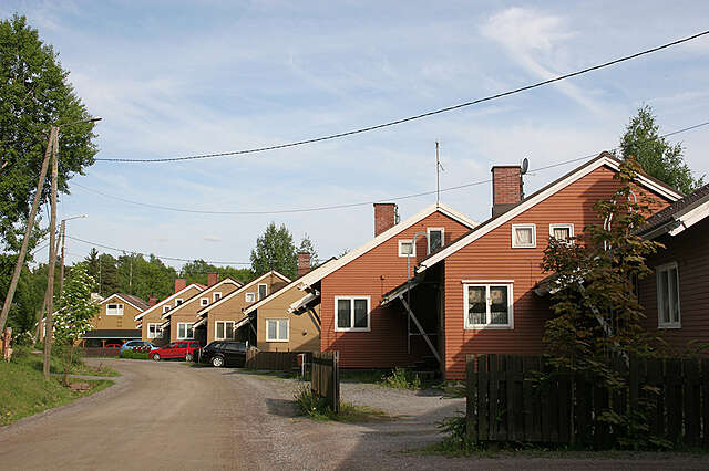 Offset row of red and brown wooden houses wit.h gable roofs and white framed windows