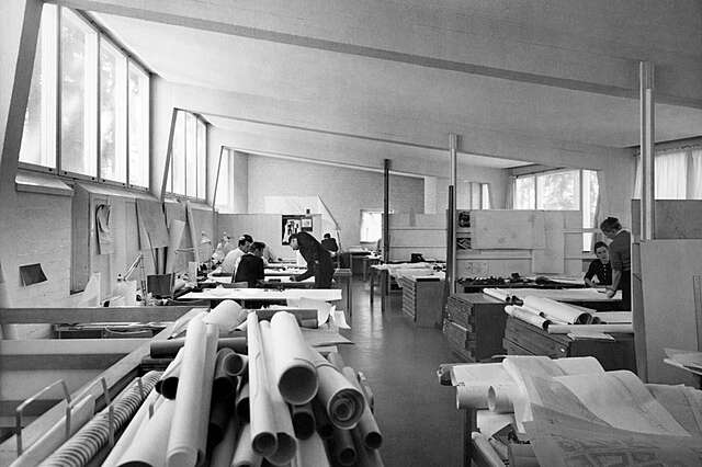 Large workspace with rolls of drawing paper at the front.