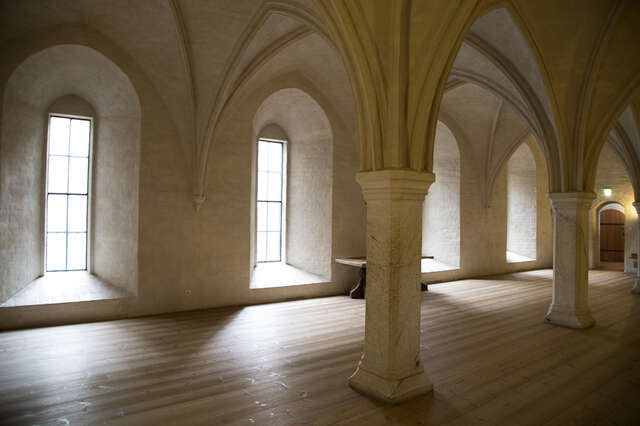 Restaurated old castle room with a groin vault ceiling and supporting pillars.
