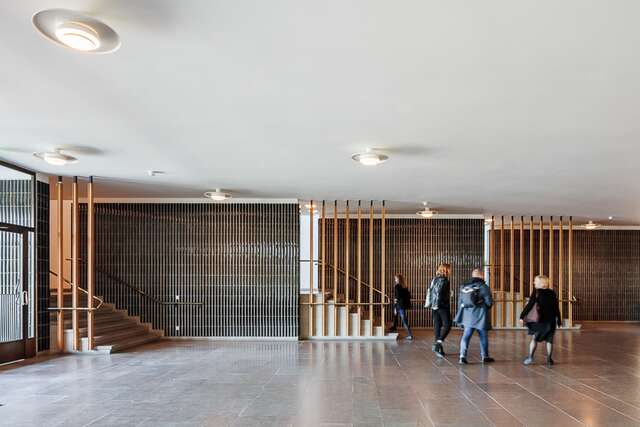 Entrance with stairs to the left and students walking towards them.