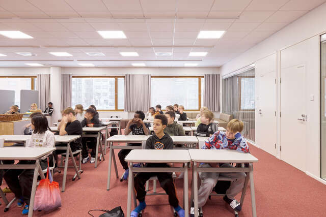 A classroom full of small children sitting at their desks.
