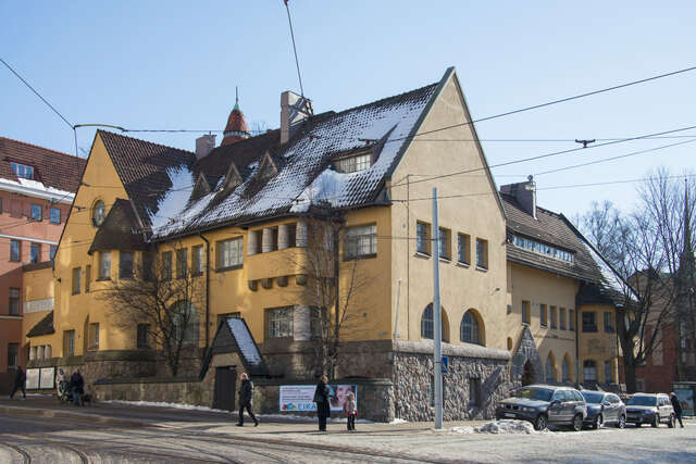 Yellow hospital facade with a stone base.