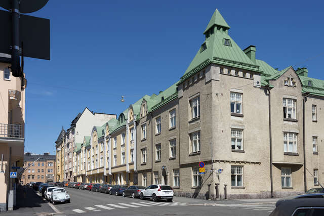 Grey plastered house at the corner of the street.