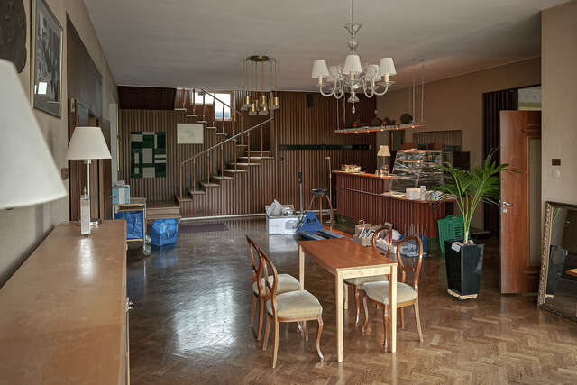 A picture of a living room with a wooden staircase leading upstairs at the back of the room.