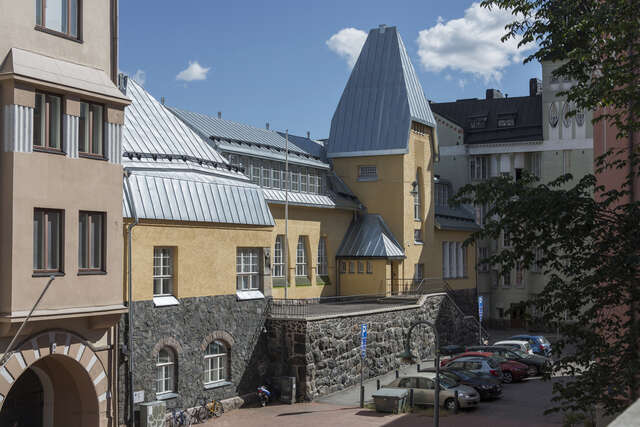 Yellow plastered building with a stone base.