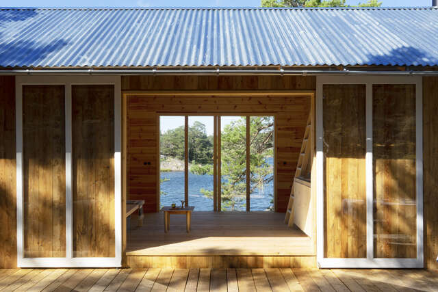 A large doorway leading into a small wooden cabin.