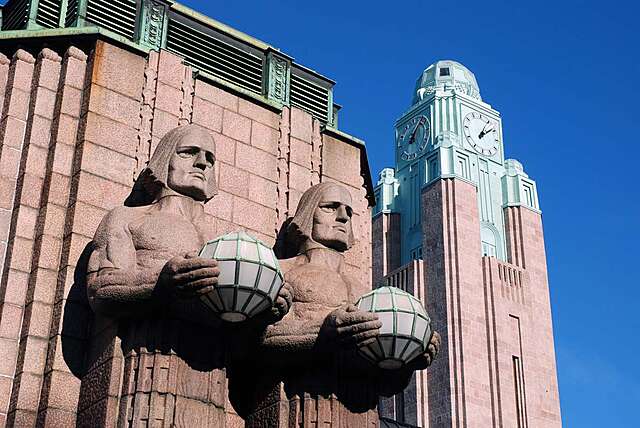 Two pairs of statues holding the spherical lamps on both sides of the main entrance next to the clock tower