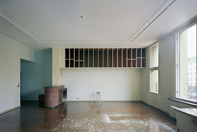 Empty living room wit a brick fireplace.