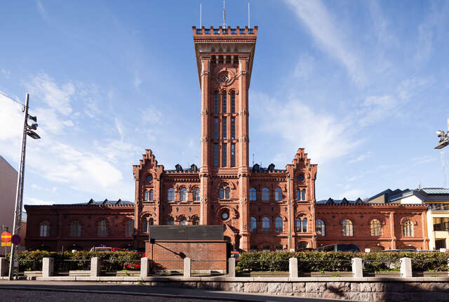 Red brick building with a high tower in the middle