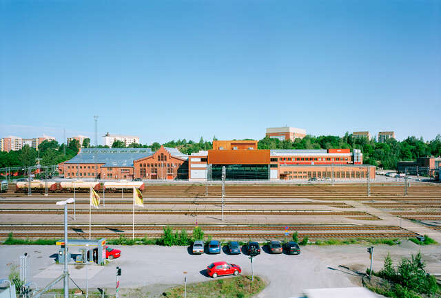 Railyard between a parking lot and old locomotive building next to annex