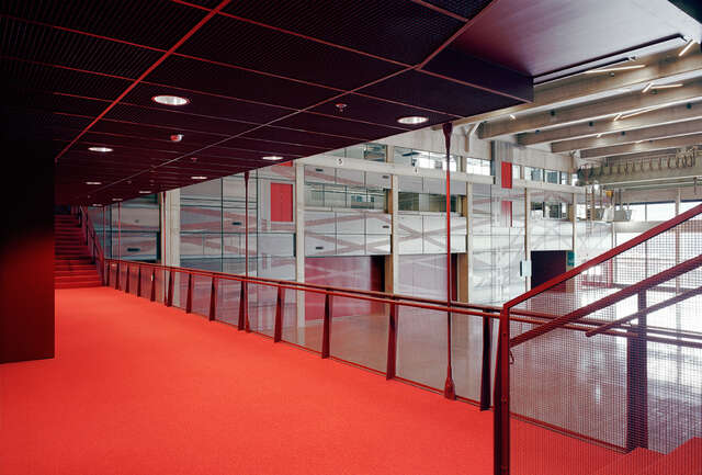 Fire red deck looking over to an industrial hall