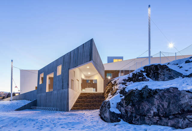 Entrance to the building next to a snowy rock.