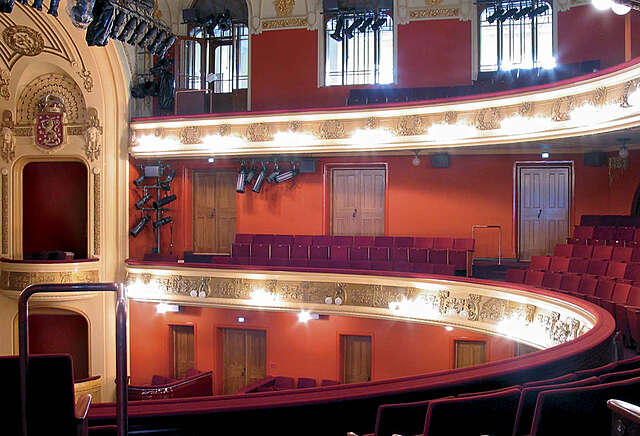 Balconies of the Finnish National theatre with their gold ornate railings and burgundy seats.