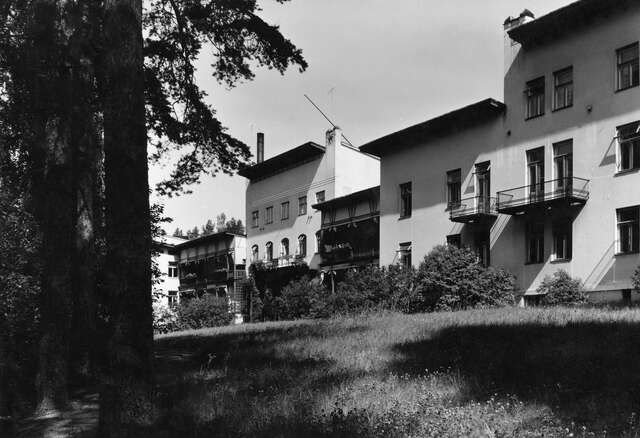 BW photograph of a hospital with green surroundings