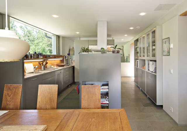 Grey-toned kitchen with a window and a sitting group in the foreground