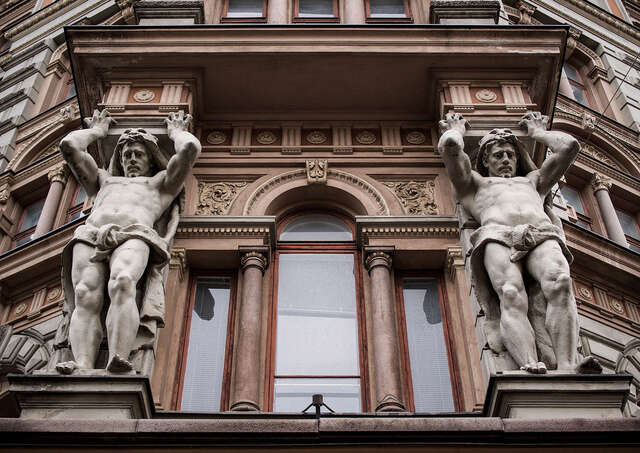 Two sculptures on the sides of a window.