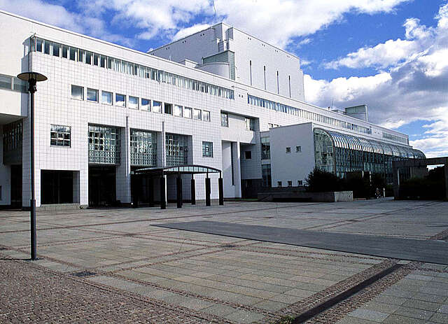 Facade covered with white square tiles and glass details..