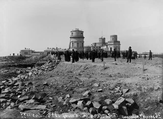 Old black and white image of people in front of the observatorium observing the arriving ships.