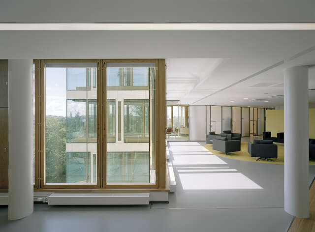 Spacious hall with large windows and armchairs.